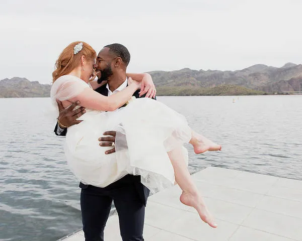 happy loving husband carrying wife while standing on pier over lake cavan images 11zon