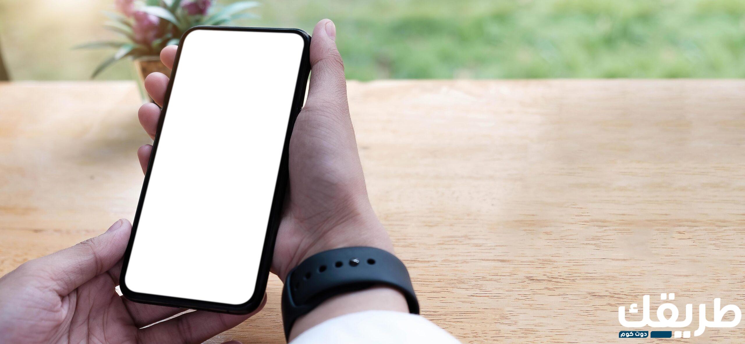 close up of person holding a cell phone with a white blank screen free photo scaled